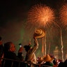 Revelers celebrate as fireworks explode over the Metropolitan Cathedral to kick off Independence Day celebrations in Mexico City, Sept. 15, 2019. 