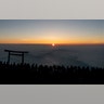People gather around a torii gate as they watch the sunrise from the summit of Mount Fuji in Japan, Aug. 3, 2019. 