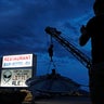 A man takes a picture of a sign at the Little A'Le'Inn during an event inspired by the "Storm Area 51" internet hoax, Thursday, Sept. 19, 2019, in Rachel, Nev. Hundreds have arrived in the desert after a Facebook post inviting people to "see them aliens" got widespread attention and gave rise to festivals this week. (AP Photo/John Locher)