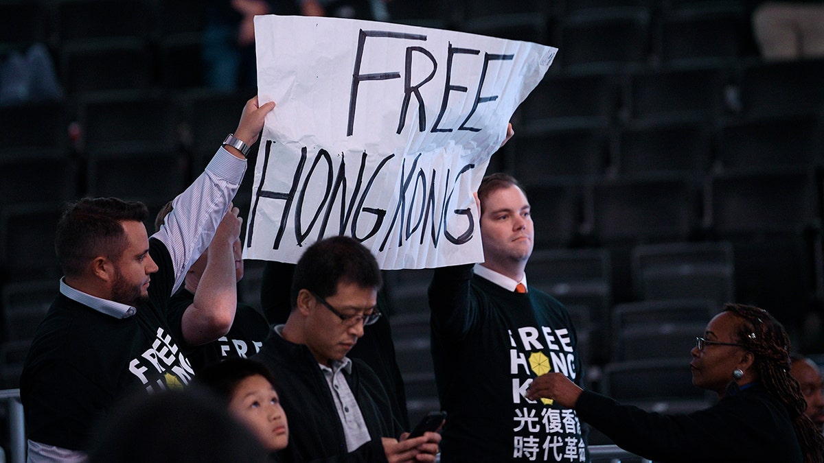 Activists hold up a sign before an NBA exhibition basketball game between the Washington Wizards and the Guangzhou Loong-Lions, Wednesday, Oct. 9, 2019, in Washington. (AP Photo/Nick Wass)