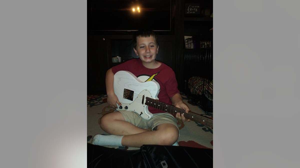 Ayden poses with his new, customized electric guitar, a gift from his favorite musical artist, Kelsea Ballerini