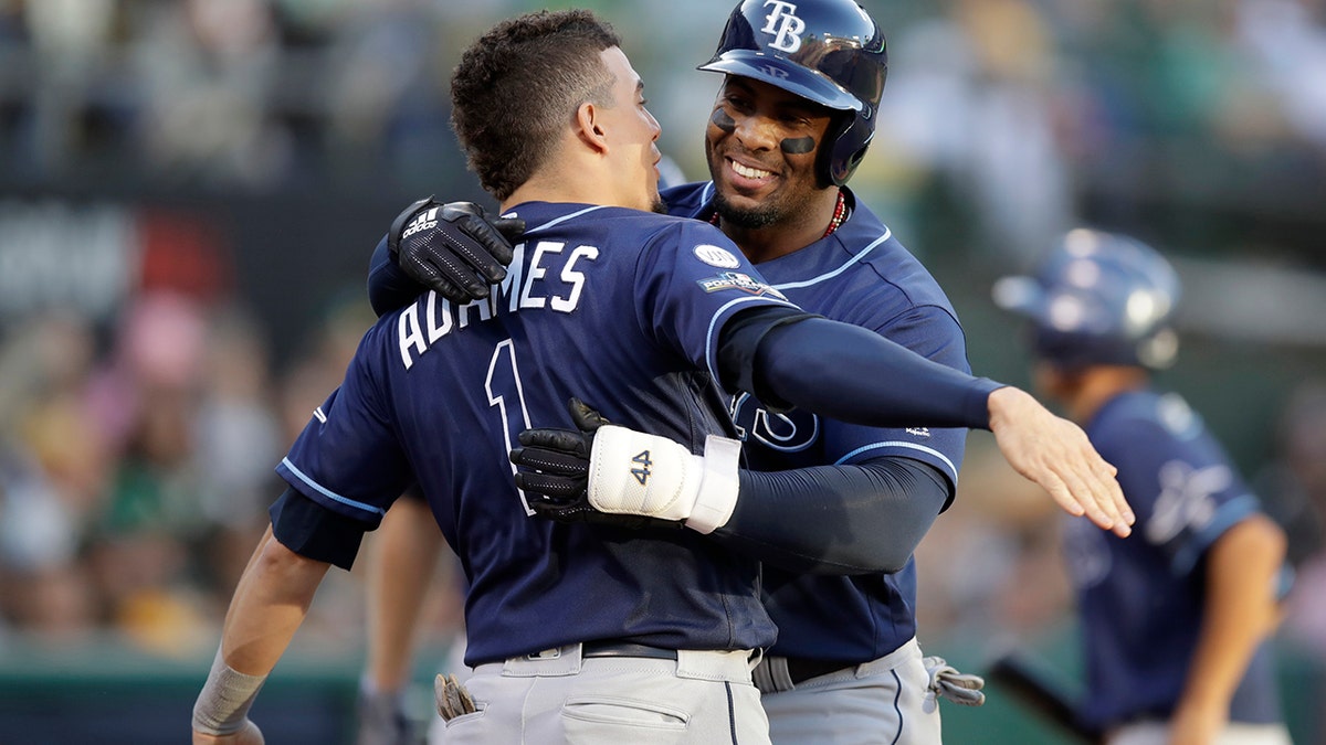 Tampa Bay Rays' Yandy Diaz, right, is congratulated by Willy Adames after hitting a solo home run against the Oakland Athletics during the third inning of an American League wild-card baseball game in Oakland, Calif., Wednesday, Oct. 2, 2019. (Associated Press)