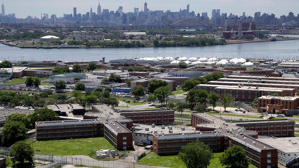 The Rikers Island jail complex, set against the backdrop of the New York City skyline.