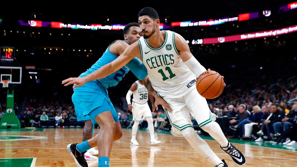 Boston Celtics' Enes Kanter (11) drives past Charlotte Hornets' PJ Washington (25) during the first half of a preseason NBA basketball game in Boston.