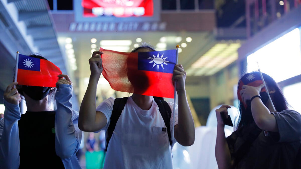 People hold Taiwanese flags as they join others at a rally to mark Taiwan's National Day, in the Tsim Sha Tsui district in Hong Kong, Thursday, Oct. 10, 2019.?