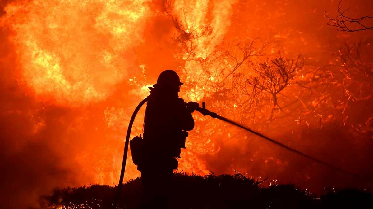 The Saddleridge fire flares up near a firefighter in Sylmar, Calif., Thursday, Oct. 10, 2019. (Associated Press)