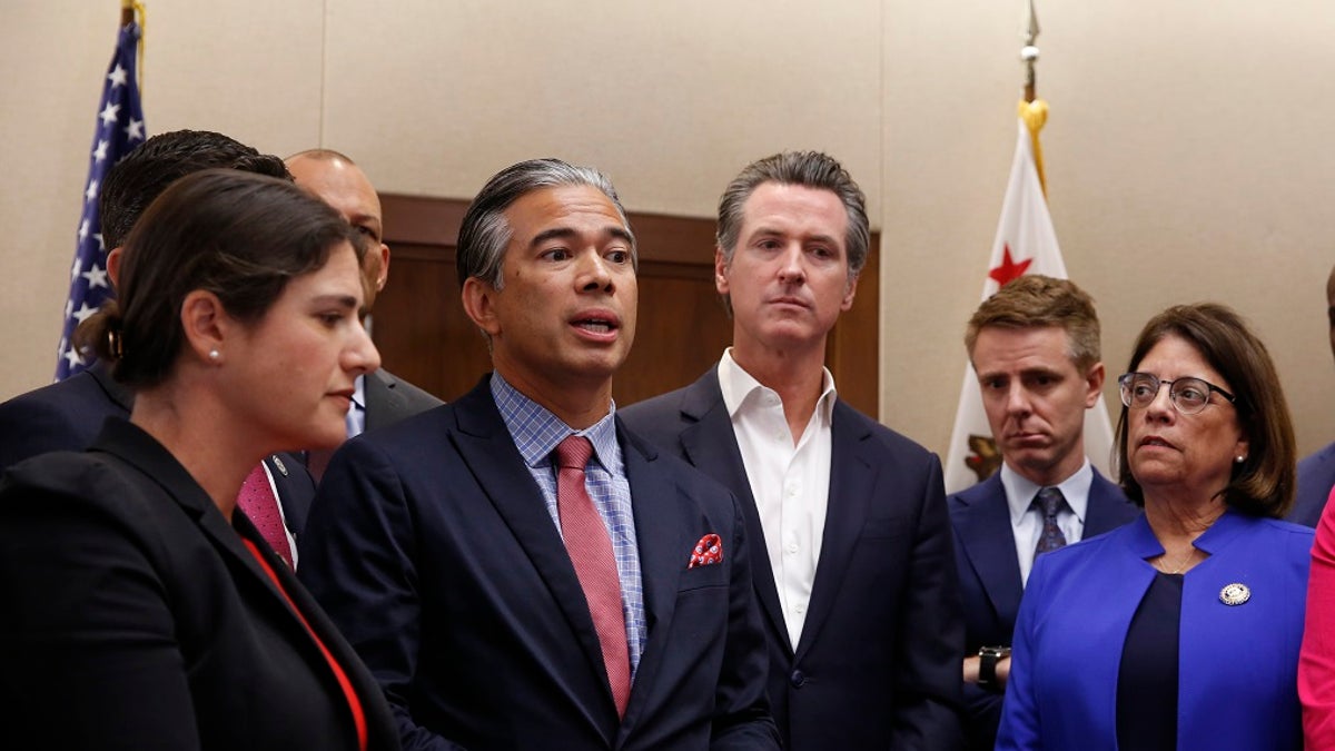 Assemblyman Rob Bonta, D-Oakland, second from left, flanked by California Gov. Gavin Newsom, center, and other lawmakers, discusses his measure on for-profit detention facilities on Friday in Sacramento.  (AP Photo/Rich Pedroncelli)