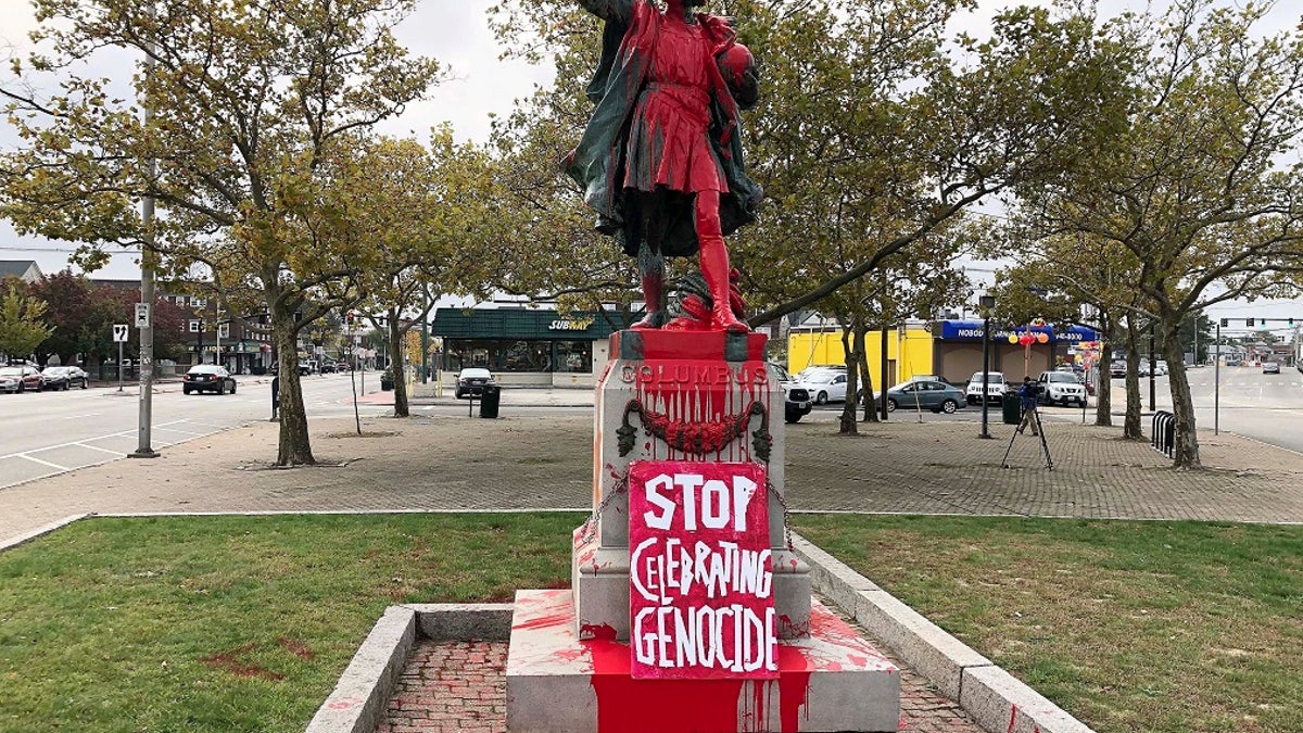 A sign reading "stop celebrating genocide" sits at the base of a statue of Christopher Columbus on Monday in Providence, R.I. (AP Photo/Michelle R. Smith)