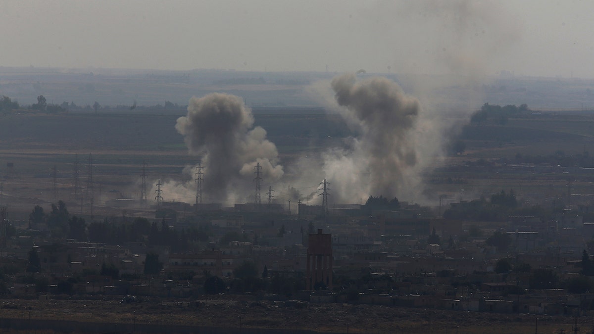 In this photo taken from the Turkish side of the border between Turkey and Syria, in Ceylanpinar, Sanliurfa province, southeastern Turkey, smoke billows from targets in Ras al-Ayn, Syria, caused by bombardment by Turkish forces, Tuesday, Oct. 15, 2019.