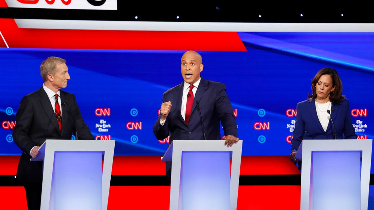 Democratic presidential candidate businessman Tom Steyer, left, and Sen. Kamala Harris, D-Calif., right, listen as Sen. Cory Booker, D-N.J., speaks during a Democratic presidential primary debate hosted by CNN/New York Times at Otterbein University, Tuesday, Oct. 15, 2019, in Westerville, Ohio. (AP Photo/John Minchillo)