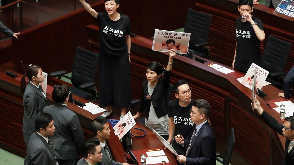 Pro-democracy lawmakers protest as Hong Kong Chief Executive Carrie Lam delivers a speech at chamber of the Legislative Council in Hong Kong Wednesday, Oct. 16, 2019. Chanting pro-democracy lawmakers have interrupted the start of a speech that Lam was giving laying out her policies.