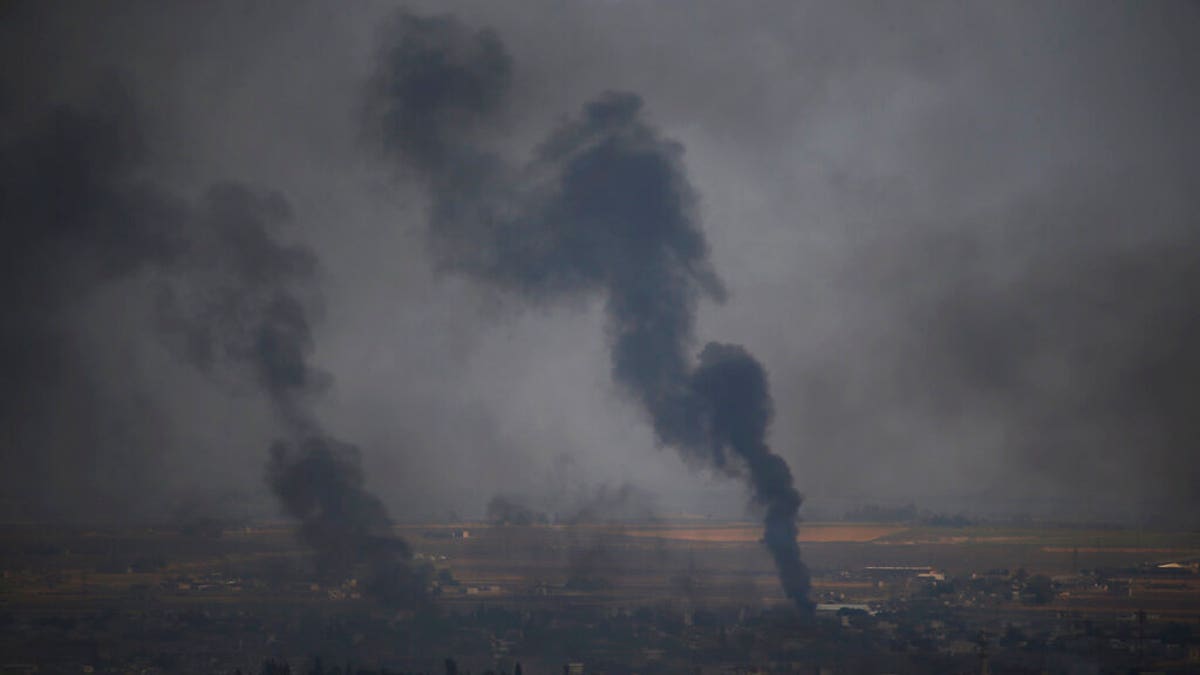 In this photo taken from the Turkish side of the border between Turkey and Syria, in Ceylanpinar, Sanliurfa province, southeastern Turkey, smoke billows from targets in Ras al-Ayn, Syria, during bombardment by Turkish forces, Wednesday, Oct. 16, 2019. Turkey's President Recep Tayyip Erdogan called Wednesday on Syrian Kurdish fighters to leave a designated border area in northeast Syria 'as of tonight' for Turkey to stop its military offensive, defying pressure on him to call a ceasefire and halt its incursion into Syria, now into its eighth day. (AP Photo/Lefteris Pitarakis)