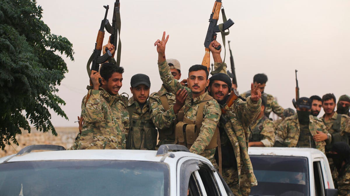 A convoy of Turkish backed Free Syria Army about to cross into Turkey near the town of Azaz, Syria, on Wednesday. (AP Photo)
