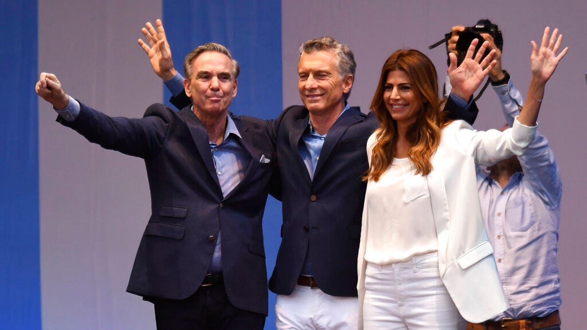 Presidential candidate for "Juntos Por el Cambio" party and Argentina's President Mauricio Macri, center, his wife Juliana Awada, right, and his running-mate Miguel Angel Pichetto, wave to supporters during a rally at "9 de Julio" avenue in Buenos Aires, Argentina, Saturday, Oct. 19, 2019. 