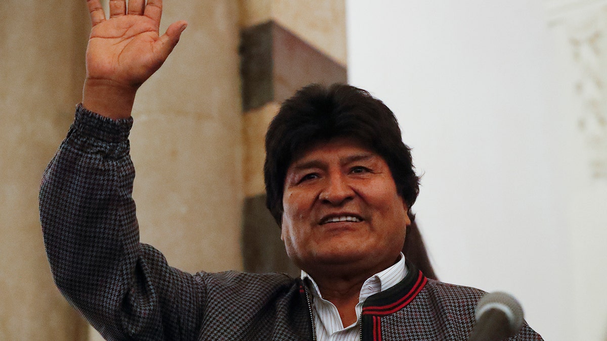 Bolivian President Evo Morales waves to supporters at the presidential palace in La Paz, Bolivia, after a first-round presidential election, Sunday, Oct. 20.