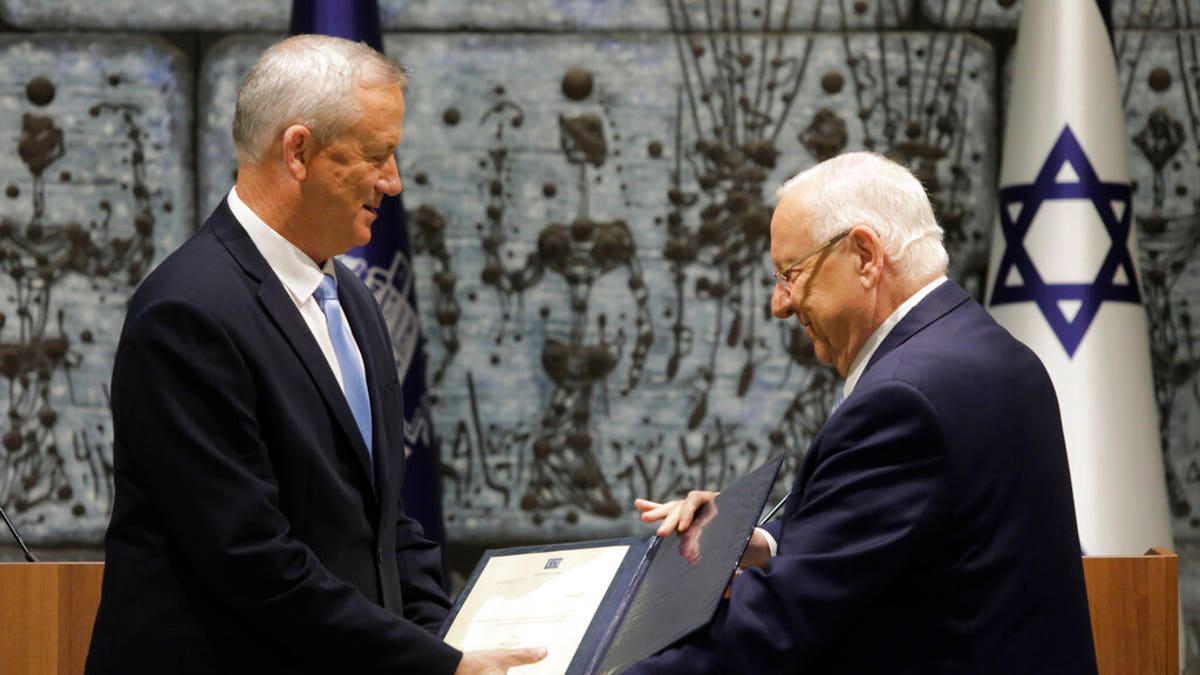 Israeli President Reuven Rivlin, right, hands a mandate to form new government to Blue and White Party leader Benny Gantz in Jerusalem, Wednesday, Oct. 23, 2019.
