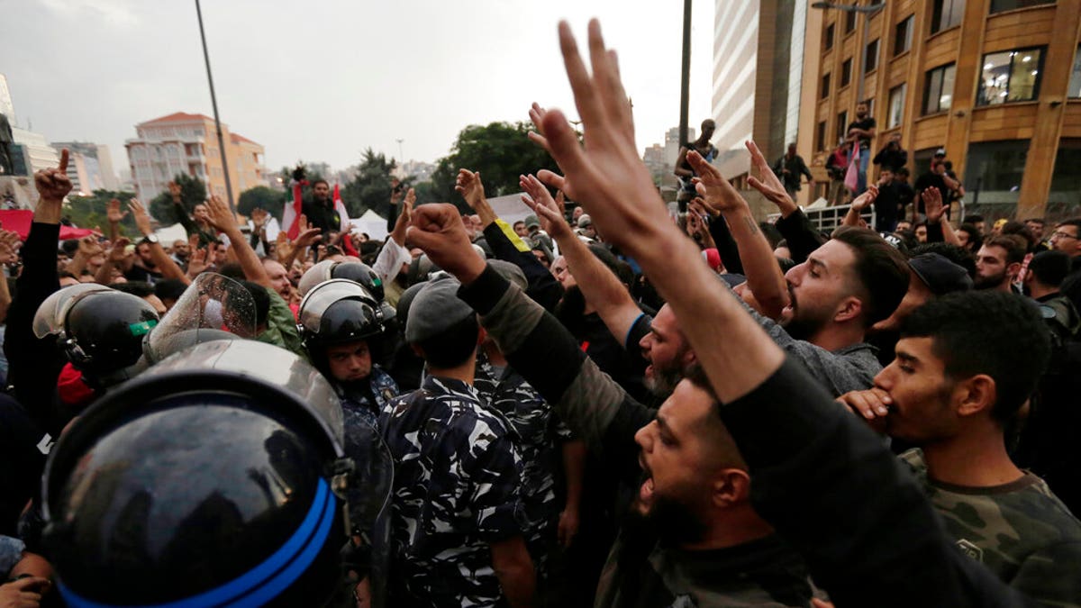 Lebanese riot policemen separates between anti-government protesters, left, and Hezbollah supporters, right during a protest in Beirut, Lebanon, Thursday, Oct. 24, 2019. 