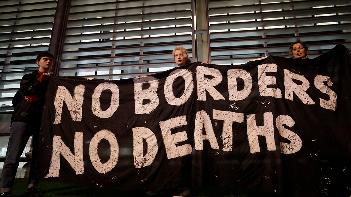 Demonstrators hold a banner during a vigil for the 39 lorry victims, outside the Home Office in London, Thursday, Oct. 24.