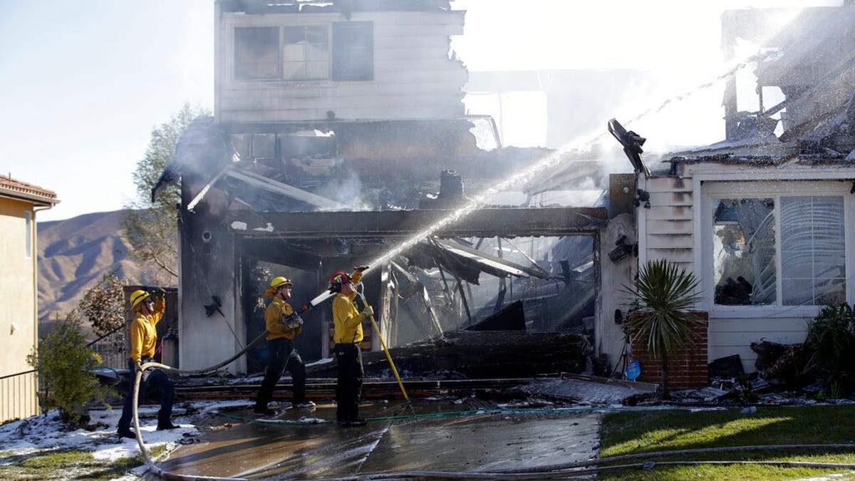 Firefighters try to put out a residence fire caused by a wildfire Friday, Oct. 25, 2019, in Santa Clarita, Calif. An estimated 50,000 people were under evacuation orders in the Santa Clarita area north of Los Angeles as hot, dry Santa Ana winds howling at up to 50 mph (80 kph) drove the flames into neighborhoods(AP Photo/Marcio Jose Sanchez)