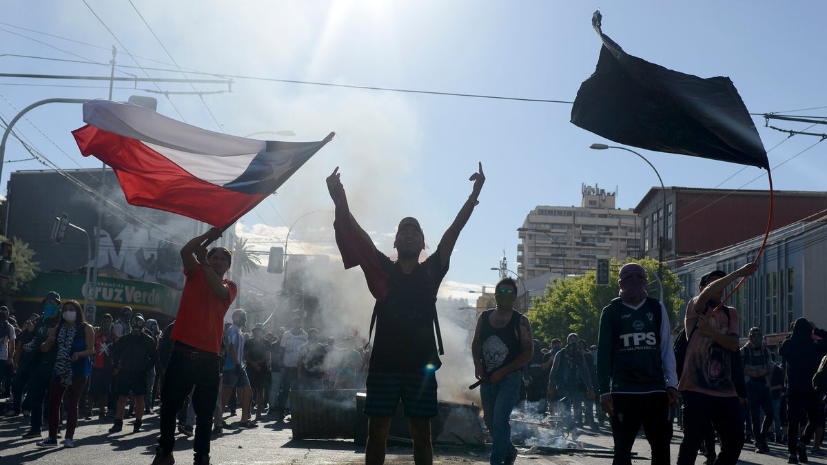 Anti-government protesters face off with police in Valparaiso, Chile, Friday, Oct. 25, 2019. A new round of clashes broke out Friday as demonstrators returned to the streets, dissatisfied with economic concessions announced by the government in a bid to curb a week of deadly violence.(AP Photo/Matias Delacroix)