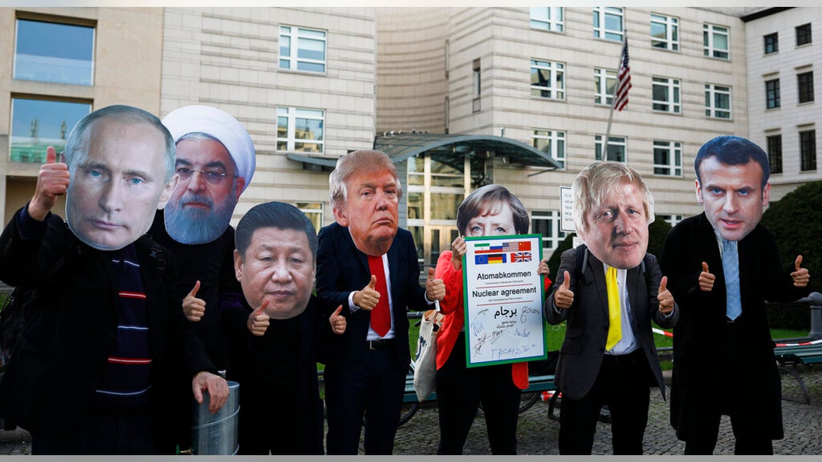 Protestors with masks of world leaders protest in front of the United States embassy, demanding a new nuclear agreement with Iran to avoid a possible armed conflict at the mideast region, in Berlin, Saturday, Oct. 26, 2019.