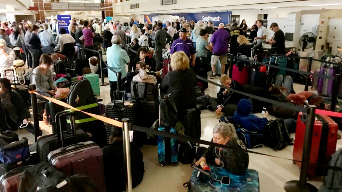 Crowds form at Louis Armstrong New Orleans International Airport after the remnants of Tropical Storm Olga knocked power out at the terminal early Saturday. (David Grunfeld/The Times-Picayune/The New Orleans Advocate via AP)