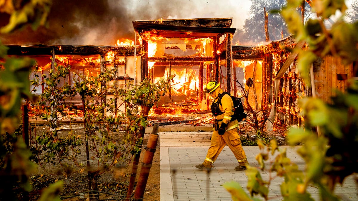 Woodbridge firefighter Joe Zurilgen passing a burning home as the Kincade Fire raged in Healdsburg, Calif., on Sunday.