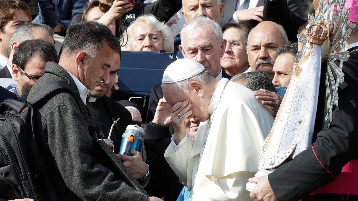 Pope Francis appears to wipe away tears as he stands in front of a plaque honoring Argentina's war dead in Argentina. (AP Photo/Andrew Medichini)