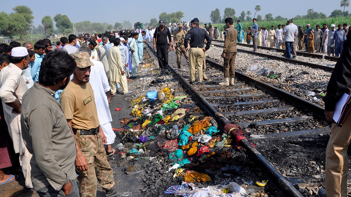 Pakistani soldiers and officials examine a train damaged by a fire in Liaquatpur, Pakistan, Thursday, Oct. 31, 2019. A massive fire engulfed three carriages of the train traveling in the country's eastern Punjab province