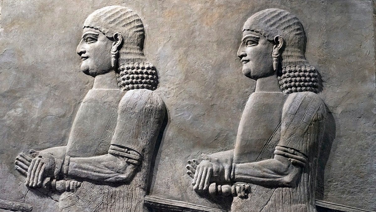 Assyrian wall relief of a genius from Mesopotamia, detail with a head. Ancient carving panel from the Middle East history. (Credit: iStock)