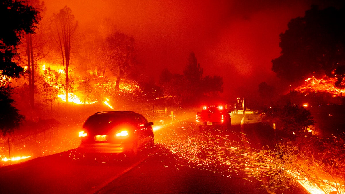 Embers fly across a roadway as the Kincade Fire burns through the Jimtown community of Sonoma County, Calif., Oct. 24, 2019.