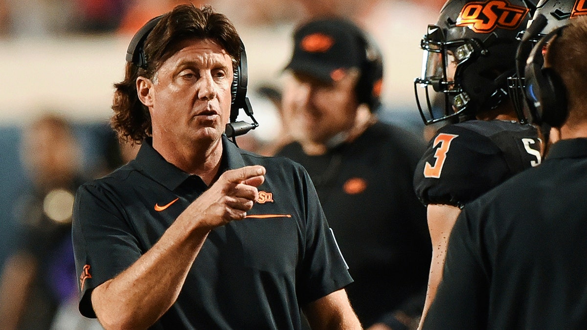 Oklahoma State head coach Mike Gundy points to his staff on the sidelines during the first half of an NCAA college football game against Kansas State, in Stillwater, Okla., Saturday, Sept. 28, 2019.