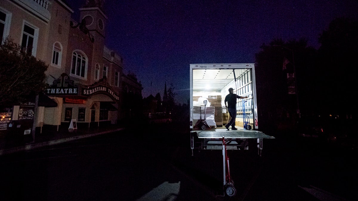 Armando Espinoza delivers paper products to a cafe in downtown Sonoma, Calif., where power is turned off, on Wednesday, Oct. 9, 2019.