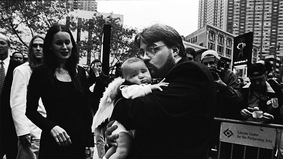 American director and screenwriter Kevin Smith holds daughter Harley Quinn dressed in angel wings on the red carpet at the premiere of this film "Dogma" in October 1999 in New York City, New York. The controversial film, a religious comedy, was protested by the Catholic League upon its release.