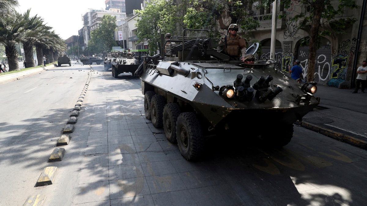 Army armored vehicles patrol the streets, after a night of riots that forced President Sebastian Pinera to announce a state of emergency, in Santiago, Chile, Saturday, Oct. 19, 2019.