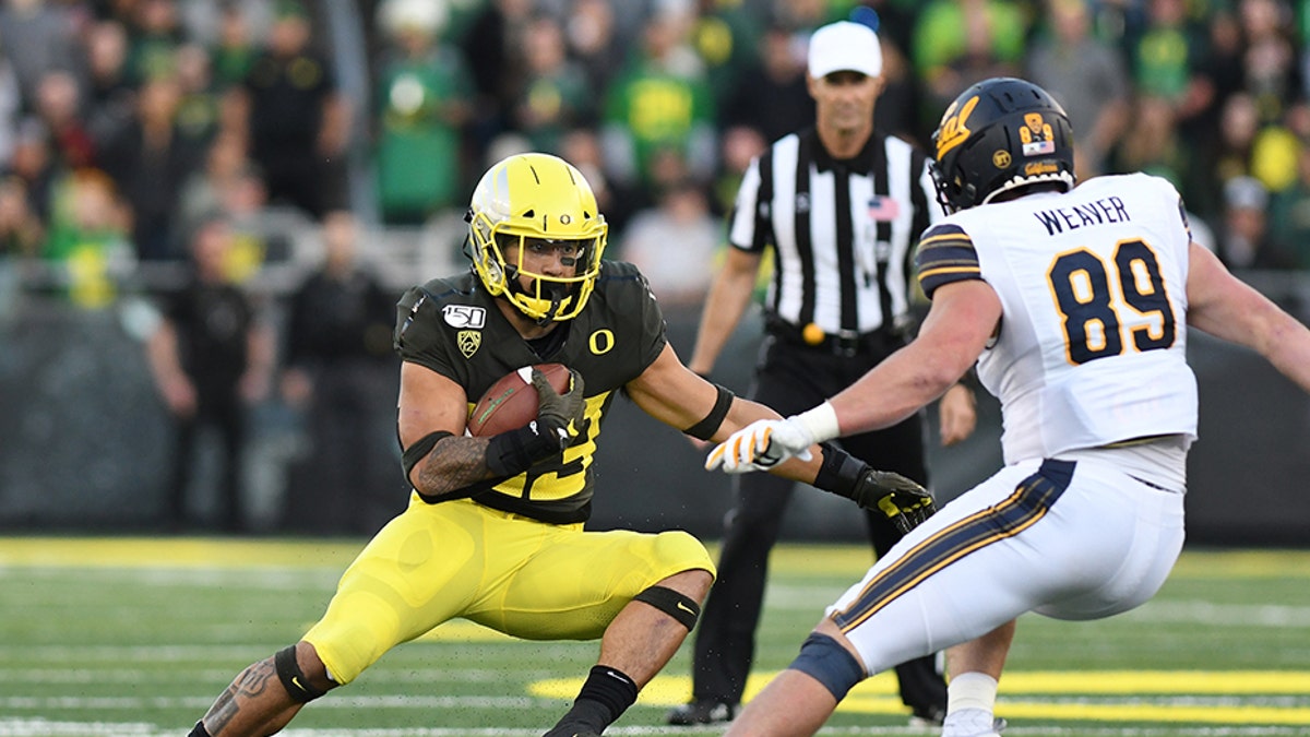EUGENE, OR - OCTOBER 05: Oregon Ducks RB Cyrus Habibi-Likio (33) runs the ball against California Golden Bears ILB Evan Weaver (89) during a college football game between the Cal Bears and Oregon Ducks at Autzen Stadium in Eugene, Oregon. (Photo by Brian Murphy/Icon Sportswire via Getty Images)