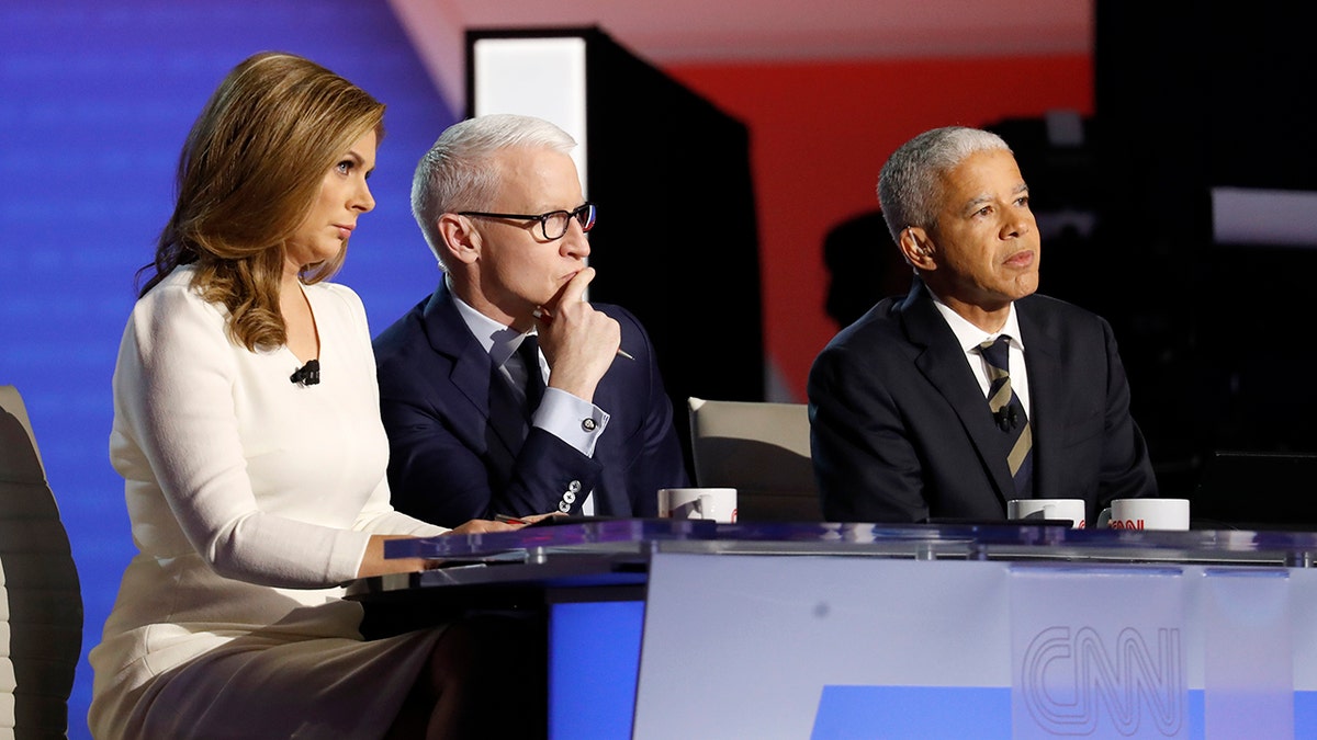 Erin Burnett, CNN anchor, from left, Anderson Cooper, CNN anchor, and Marc Lacey, New York Times national editor, listen during a Democratic presidential primary debate hosted by CNN/New York Times at Otterbein University, Tuesday, Oct. 15, 2019, in Westerville, Ohio. (AP Photo/John Minchillo)