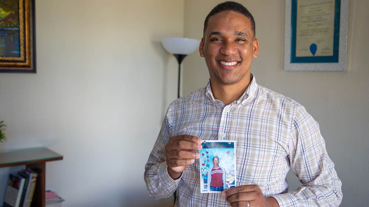 Jose Frank holds one of his sponsorship photos from childhood.