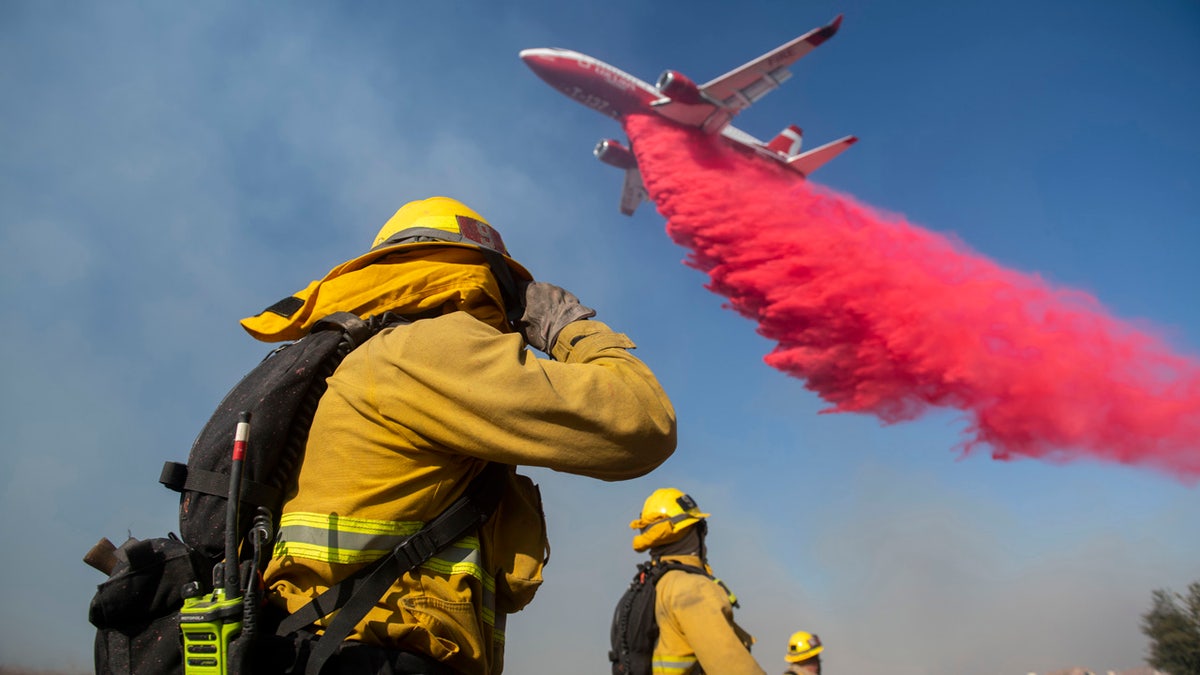 Firefighters brace themselves for incoming fire retardant during the Easy Fire, Wednesday, Oct. 30, 2019, in Simi Valley, Calif.