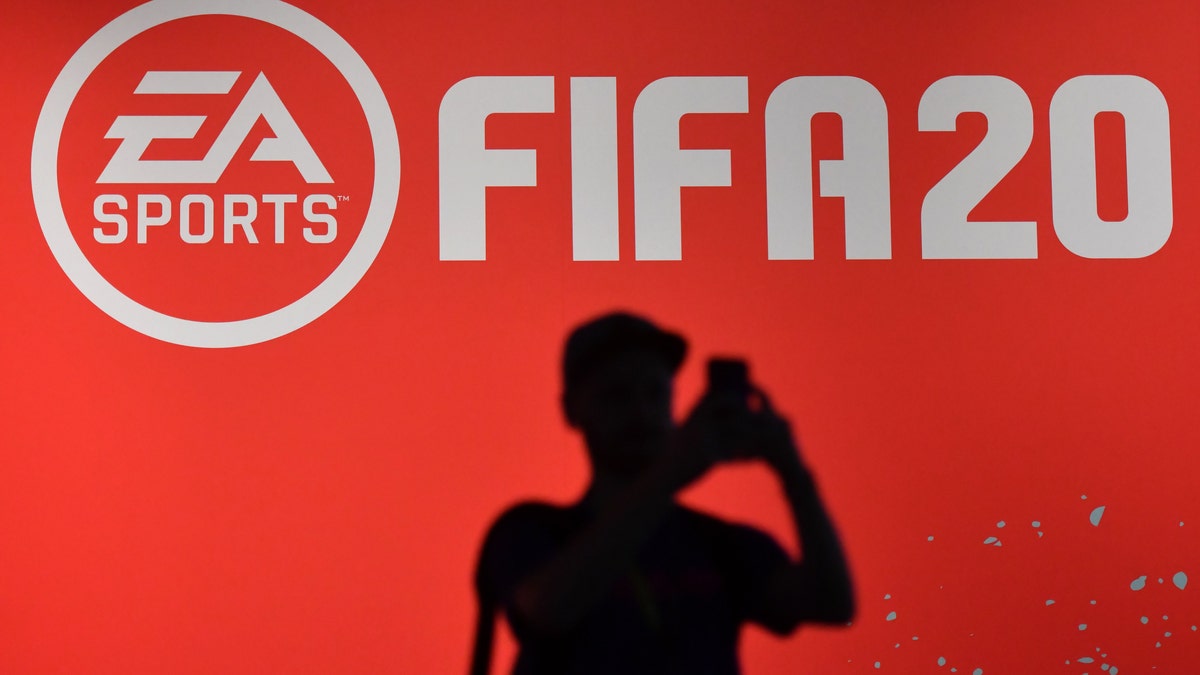 A visitor takes a picture at the booth of the "FIFA 20" football game at the Gamescom video games trade fair in Cologne, western Germany, on August 20, 2019 - file photo.