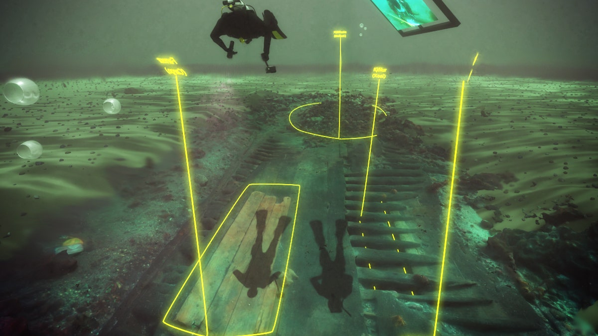A scene from the virtual dive, with divers swimming over the wreck as it appears today, with areas of the wreck labeled in yellow.