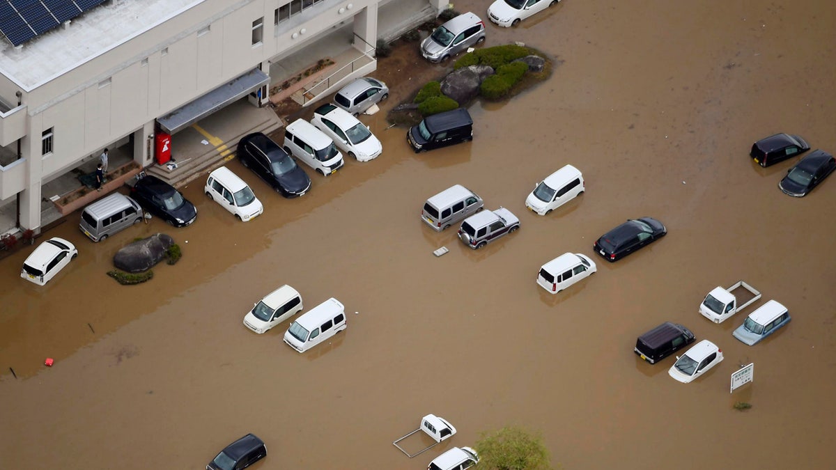 Vehicles are seen under water following the typhoon-hit town of Marumori, Miyagi prefecture, Japan , Monday, Oct. 14, 2019. 