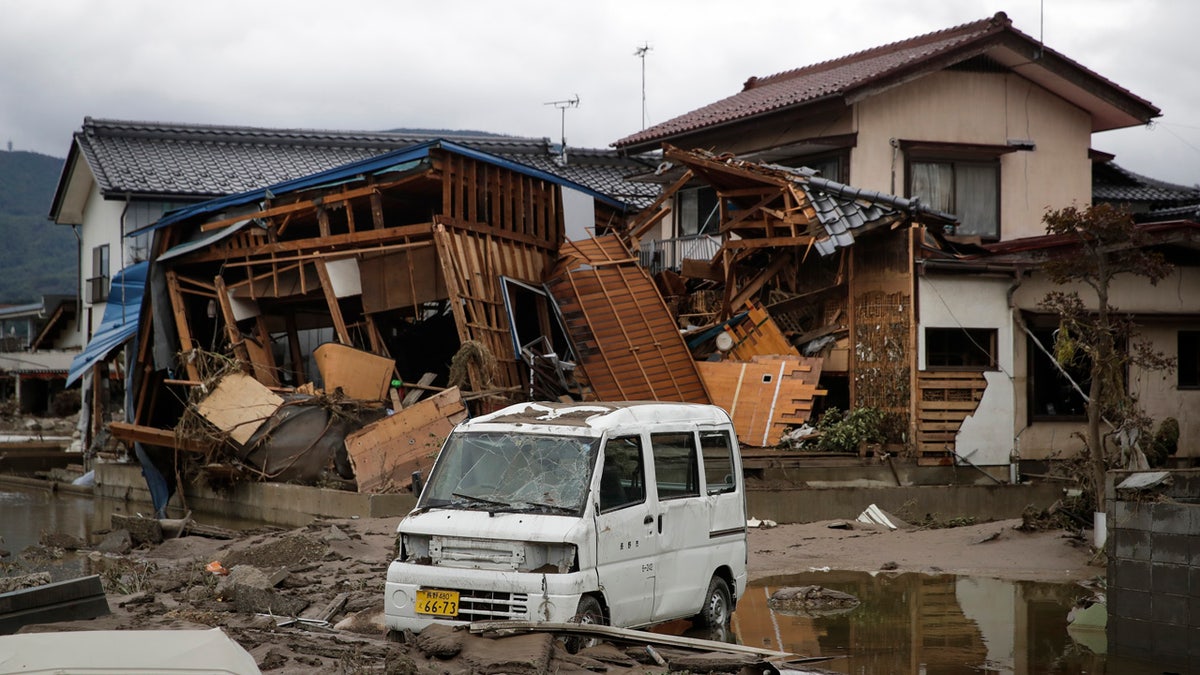 A vehicle sits in front of a home destroyed by Typhoon Hagibis Tuesday, Oct. 15, 2019, in Nagano, Japan.