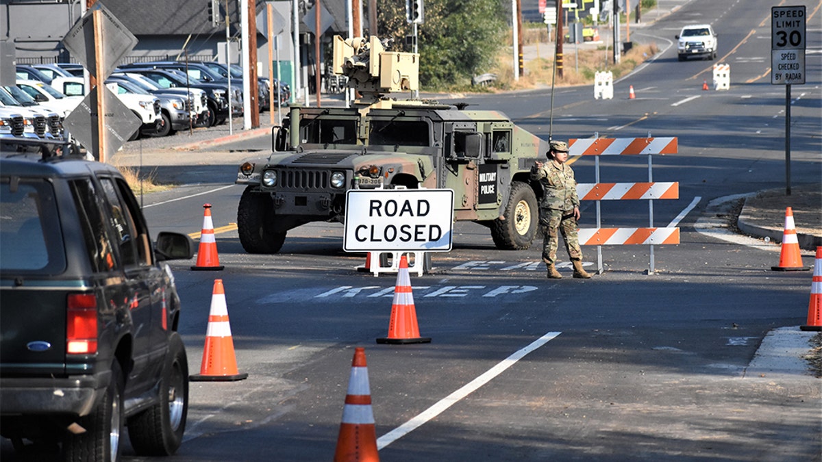 A member of Cal Guard blocks traffic from entering the town of Healdsburg on Monday following an evacuation order.