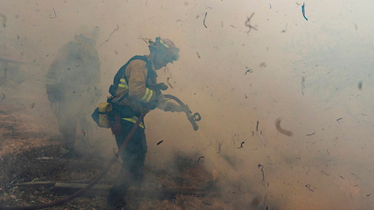 Firefighters from San Matteo work to extinguish flames from the Kincade Fire in Sonoma County, Calif., on Sunday, Oct. 27, 2019.