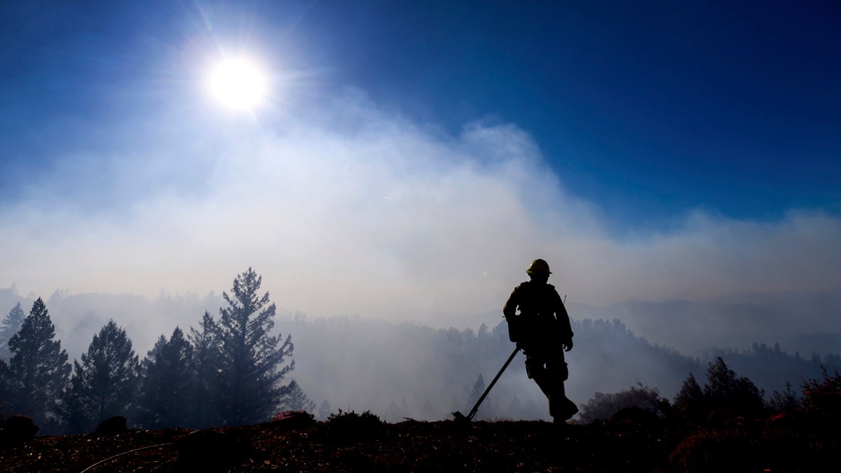 Firefighter Josh Petrell monitors the Kincade Fire burning near Healdsburg, Calif., on Tuesday, Oct. 29, 2019. AP Photo/Noah Berger