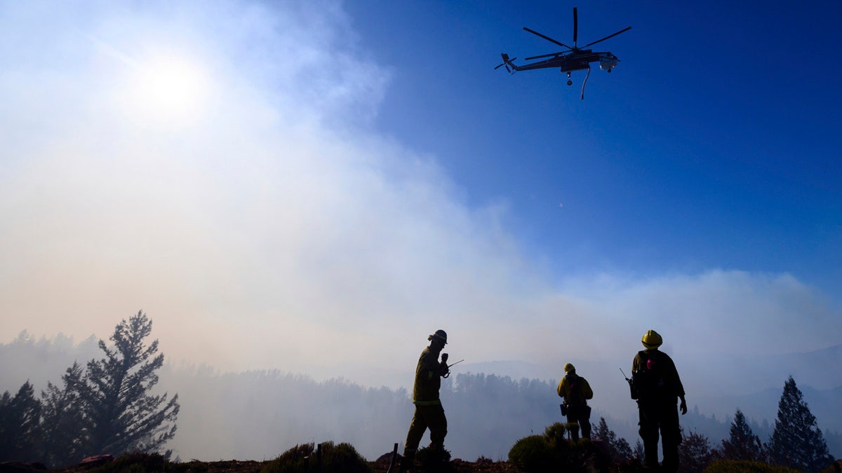 Firefighters monitor the Kincade Fire burning near Healdsburg, Calif., on Tuesday, Oct. 29, 2019.