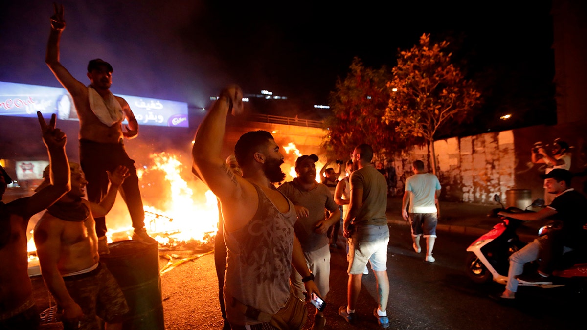 Lebanese demonstrators chant slogans as a fire burns during a protest against recent tax calls on Thursday in Beirut. (Anwar Amro/AFP via Getty Images)