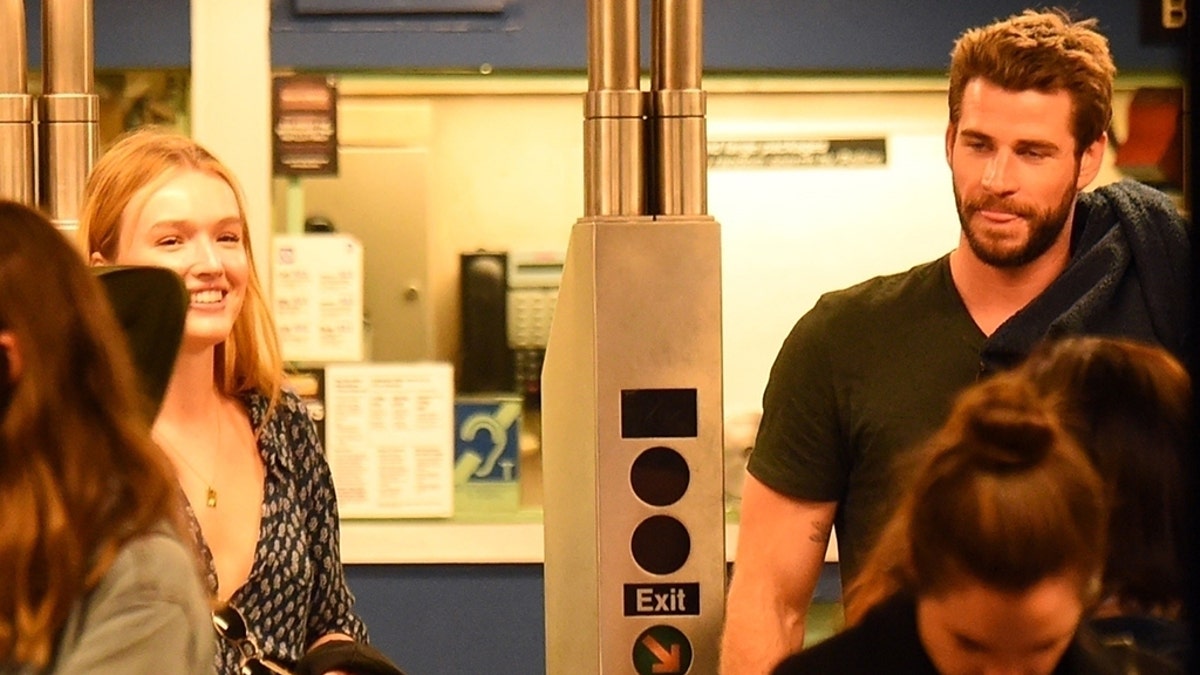 Liam Hemsworth is seen with an ear to ear smile in the underground subway with actress Maddison Brown in Soho, New York. (Backgrid)