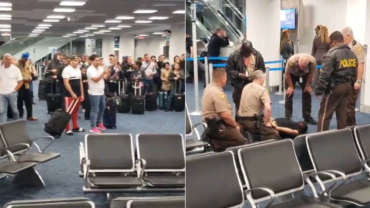 Passengers at the Miami International Airport look on after the man was removed from the plane and detained by police on Monday morning.
